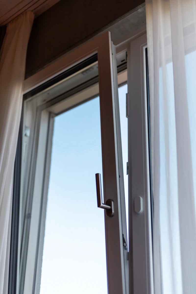 Instalación de Ventanas Eléctricas en Medellín Ventana abatible con apertura eléctrica; detalle de manija y sistema automatizado para control interior